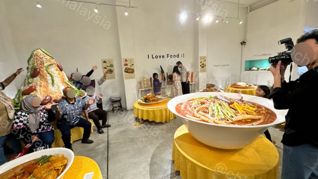 巨大チェンドルの前でフォーメーション撮影をするマレー系家族